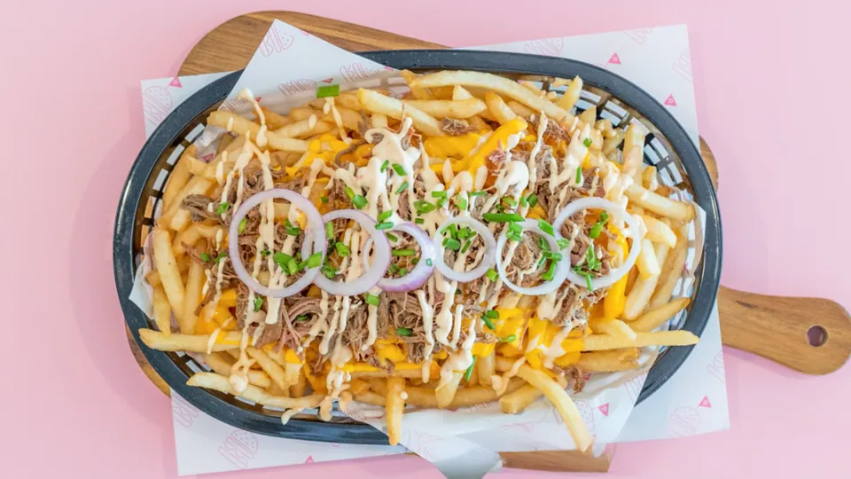 Cheesy Beefy Fries – Thin + crispy fries topped with smokey pulled beef, cheesy sauce, chipotle mayo + pickled onions.