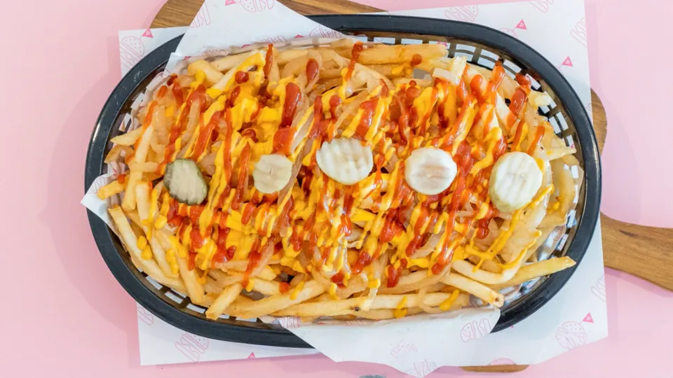 Ugly Good Fries – Thin + crispy fries topped with cheesy sauce, caramelized onions, mustard, ketchup + spicy pickles.